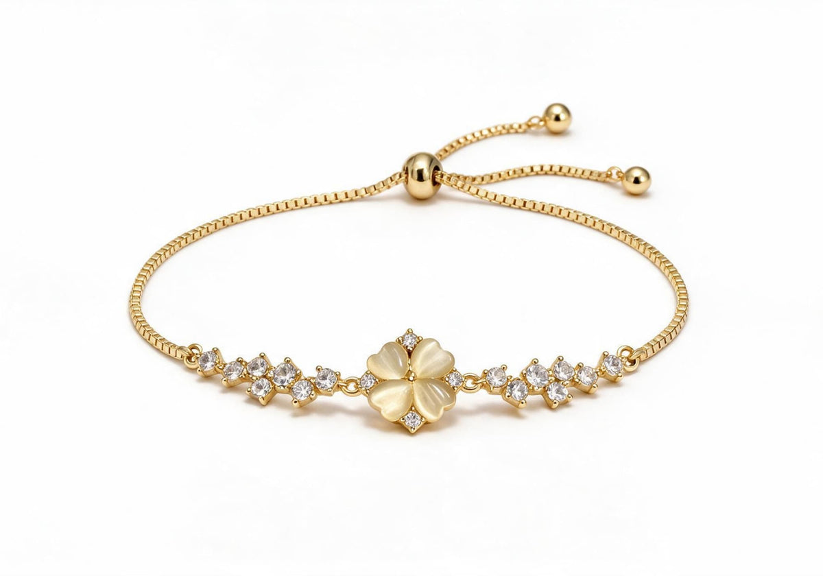 Gold box chain adjustable bracelet featuring a milky white cat-eye four-leaf clover centerpiece with clear zircon accents.