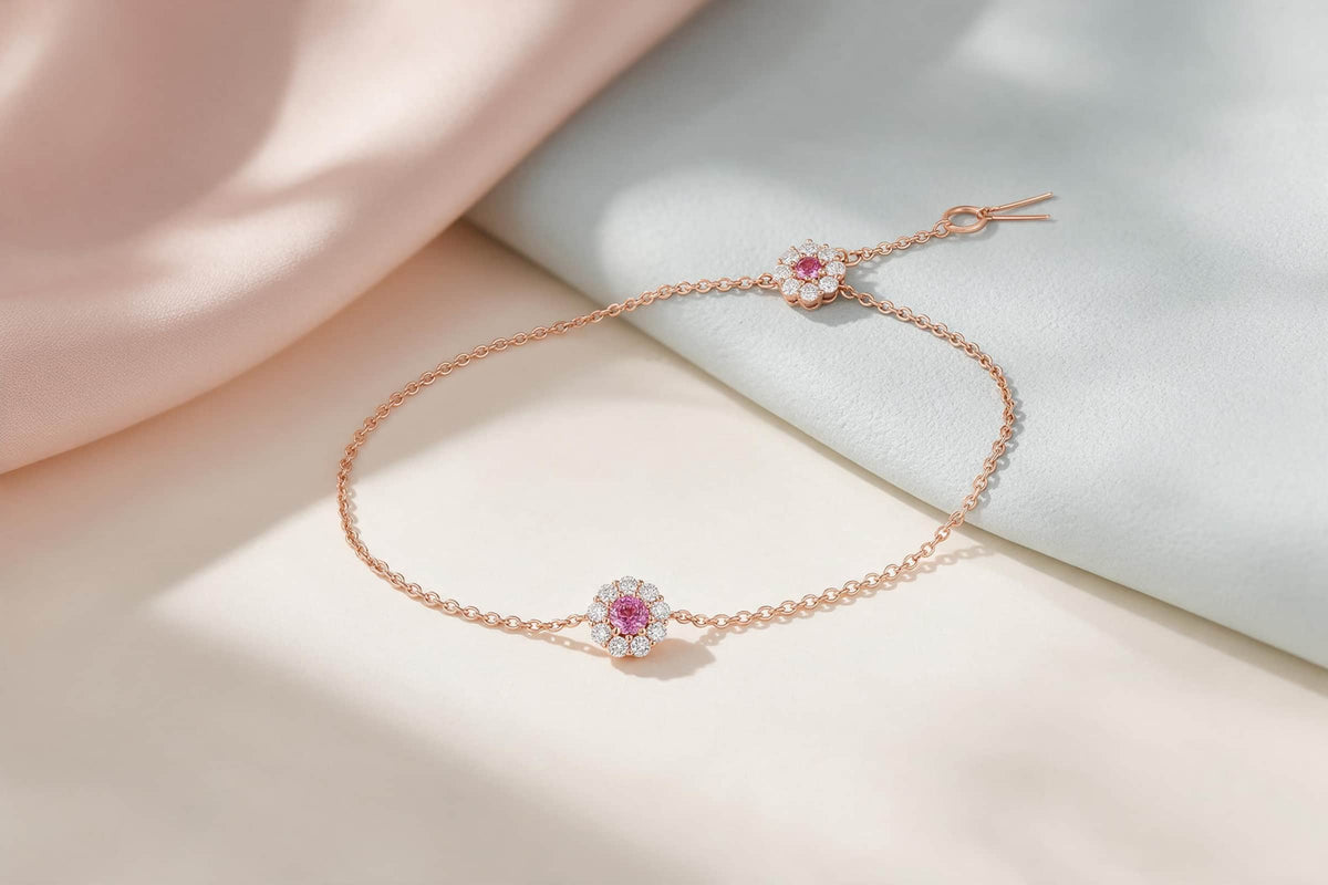 MAROVA JEWELS dainty rose gold chain bracelet with dual pink gemstone flower charms surrounded by diamond halo, adjustable delicate bracelet laid on soft beige and pink satin, romantic fine jewelry display