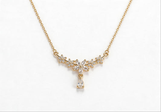 Gold-plated statement necklace featuring five zirconia flowers and an oversized zirconia drop pendant