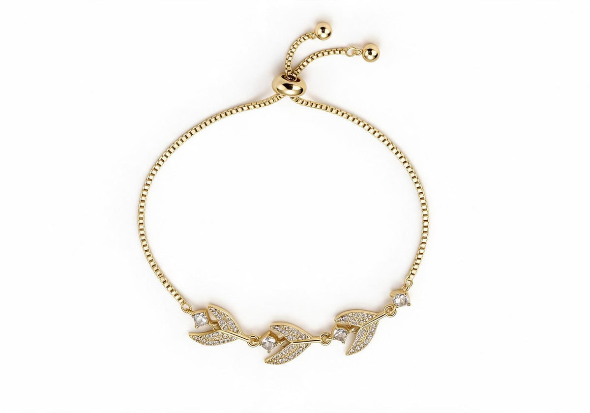 Gold box chain adjustable bracelet featuring pave wheat leaf designs and teardrop clear zirconia crafted in titanium steel.