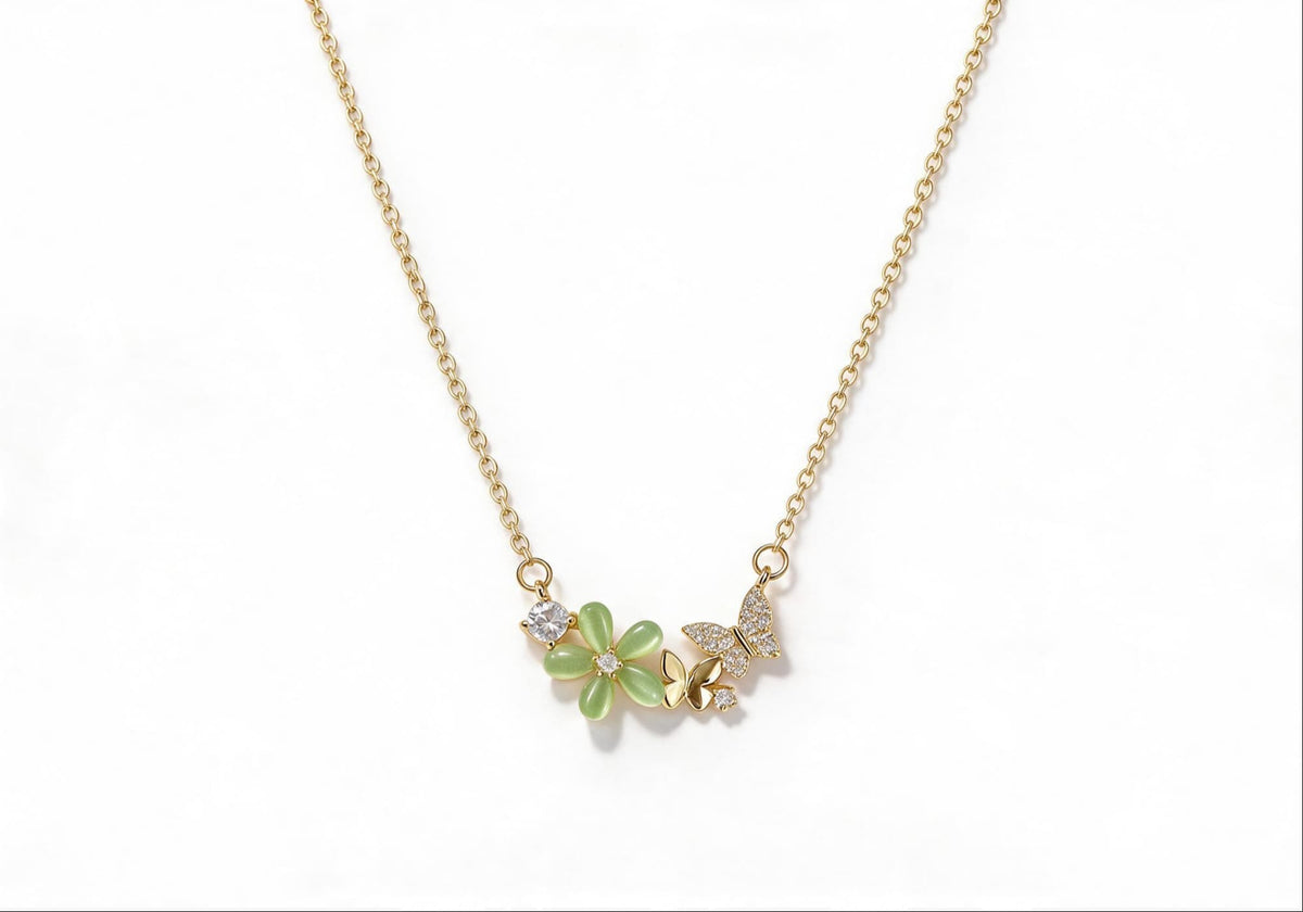 Gold-plated necklace featuring a green gemstone flower and a zirconia-encrusted butterfly