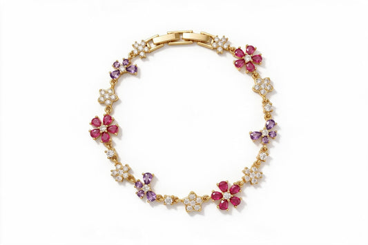 MAROVA JEWELS gold-plated floral charm bracelet adorned with alternating pear-cut red cubic zirconia flower motifs, purple four-petal CZ flowers and pavé CZ blossom stations, linked by delicate chain with a polished H-clasp, luxury fashion jewelry on clean white background