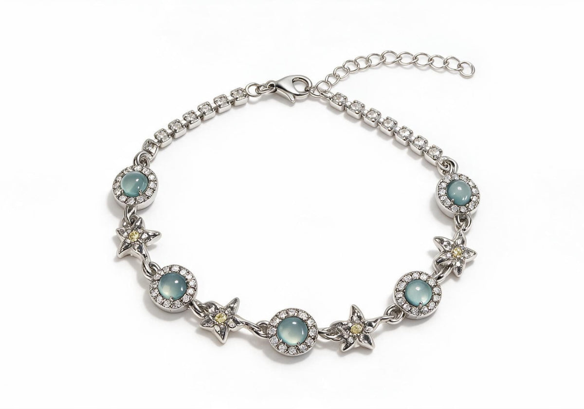 Silver titanium steel bracelet featuring light blue cat-eye stones, hollow star charms with yellow gems, and pave-set tennis chain ends.