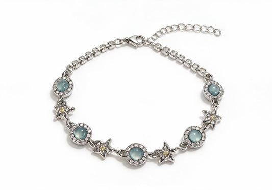 Silver titanium steel bracelet featuring light blue cat-eye stones, hollow star charms with yellow gems, and pave-set tennis chain ends.