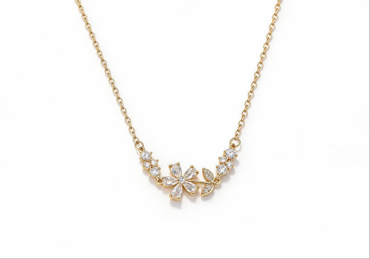 Gold-plated brass necklace featuring a delicate flower and leaf pendant with white zirconia stones